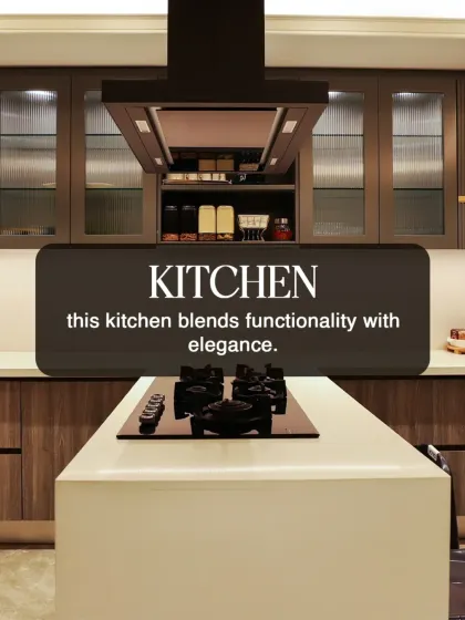 This modern kitchen blends functionality with elegance, featuring an island cooktop and a sleek chimney. The wood-finish cabinets and clean lines are hallmarks of our contemporary design aesthetic.