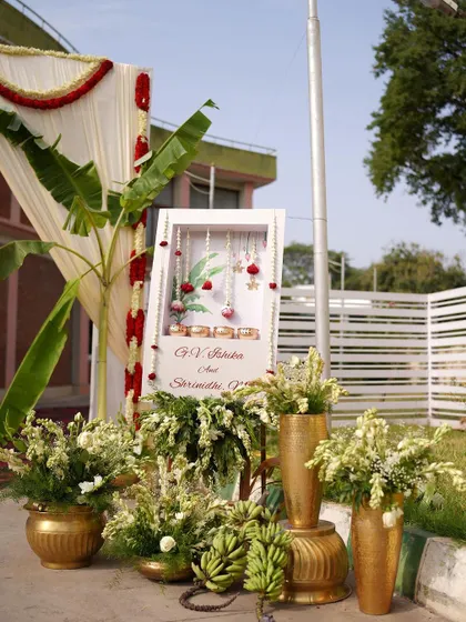 The complete traditional welcome area, with a personalized sign, brass pots, fresh bananas, and floral arrangements.