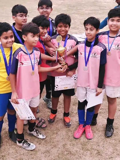 Our Under-13 players huddle together with their trophy. These shared moments of success are what build a strong and supportive team environment.