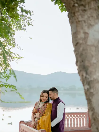 An intimate embrace under a tree, with the tranquil Jal Mahal in the distance. This shot combines natural beauty with iconic architecture for a perfect romantic portrait.