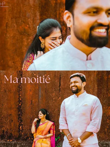 A playful and candid shot of a couple in traditional attire against a rustic wall. The bride's shy laugh and the groom's happy expression make this a heartwarming moment.
