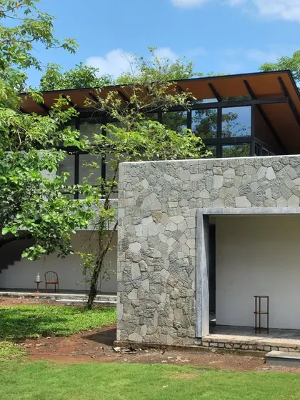 A detail of the Villa in the Grove, where bedrooms are suspended like lanterns in the tree canopies. The use of local stone grounds the structure, making the outdoor living experience feel more natural.