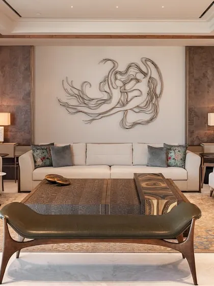 A full view of the living room, showcasing how the different furniture pieces work together to create a cohesive and sophisticated design. The sculptural bench in the foreground adds a unique, artistic touch.