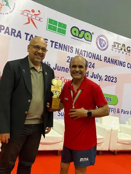 Gajanan Parmar receives his gold medal trophy from an official at the UTT 1st Para Table Tennis National Ranking Championship.