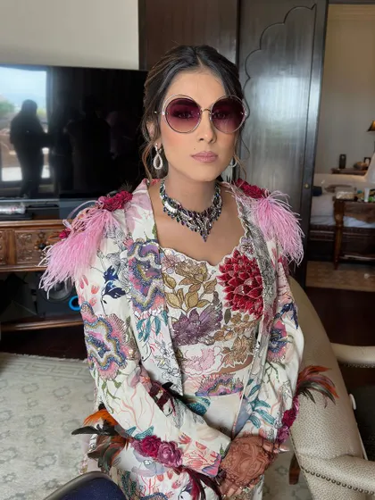 A chic and colorful look for a carnival party, featuring a textured low ponytail adorned with small pink flowers.