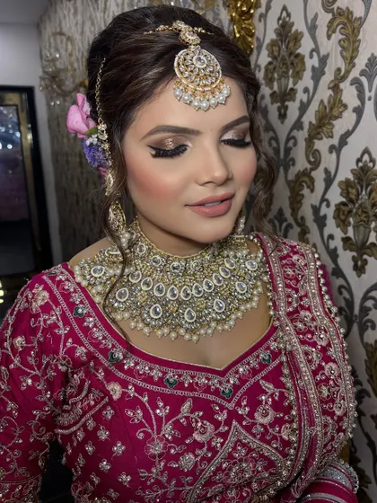 A close-up on the eye makeup, featuring a soft cut-crease with a touch of gold glitter. This technique adds dimension and glamour without being overpowering, perfect for a wedding ceremony.