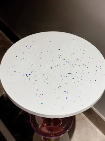 A close-up of the "Floss" table's top, showing the beautiful minimal blue terrazzo. This handmade detail adds a unique texture and a subtle splash of color.