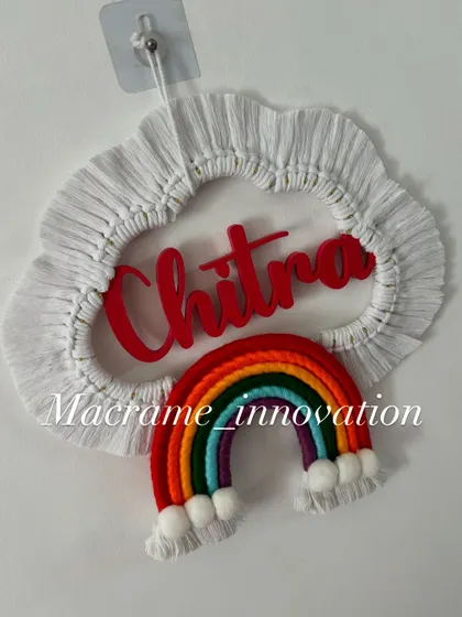 The 'Chitra' name hanging in natural light, showing the bright red name and the colorful rainbow design.