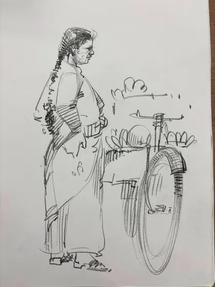 A quick line sketch of a woman standing by her bicycle.