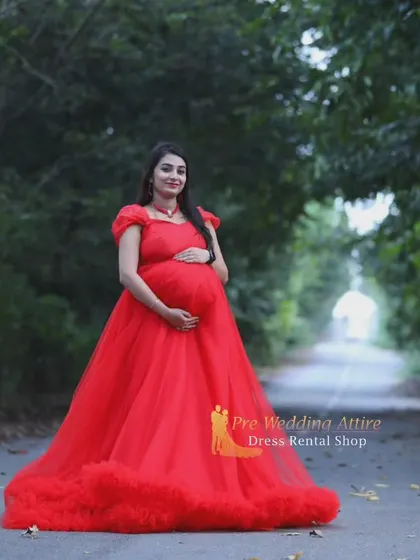 This red ruffled gown features a long train that adds a touch of drama. It's a versatile piece that combines the elegance of ruffles with the impact of a flowing train for stunning maternity portraits.