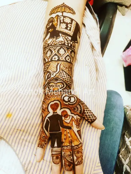 A perfect design for a ring ceremony, this mehndi features a portrait of the couple, their initials, and wedding rings, along with a majestic elephant motif on the forearm.