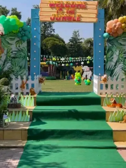 The "Welcome to the Jungle" entrance gate, with a green carpet walkway leading into the party area.