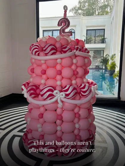 Balloons are not just playthings, they are couture. This two-tiered pink balloon cake is a perfect example of how we elevate balloon decor into a sophisticated art form.