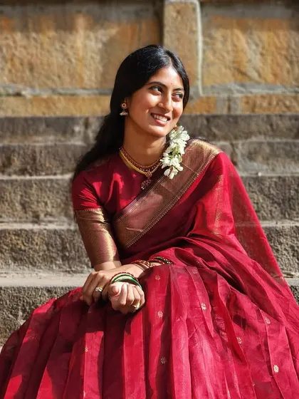 A classic and timeless look. This deep red half saree, crafted from rich silk, is perfect for any traditional ceremony. The simplicity of the design is elevated by the luxurious fabric and the traditional gold border.