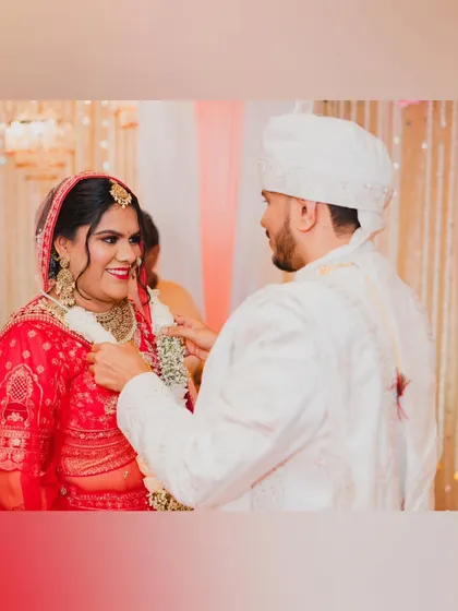 A candid shot of the couple during their Varmala ceremony, sharing a smile and a happy moment.