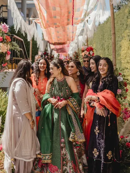 The bride with her squad at her Ooty mehendi. The lush green backdrop of the hills made their colorful outfits pop.