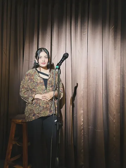 Under the spotlight with the microphone, ready to perform. This space allows me to explore the nuances of language, much like I do when crafting legal arguments.