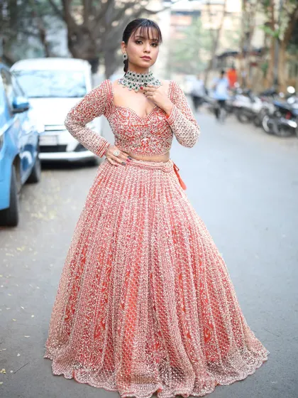 This pose highlights the modern design of the lehenga and the stylish choker necklace.