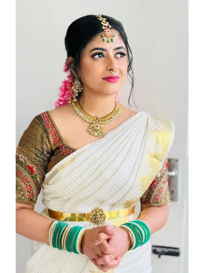 A traditional South Indian look, complete with a white and gold saree, temple jewelry, and flowers in my hair.