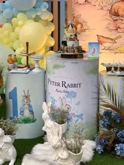 A close-up of the dessert table, featuring a beautifully detailed cake and themed props from the world of Peter Rabbit.