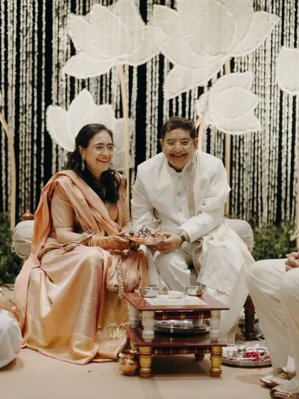Parents often get their 'second innings' at their children's weddings. This candid shot captures the pure happiness of the bride's parents during the ceremony, dressed in timeless handloom pieces that we helped them select.