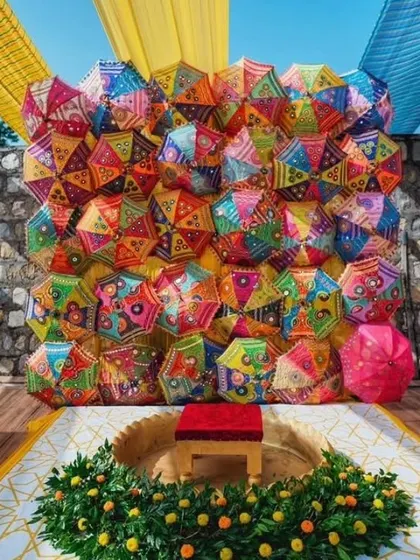 A stunning and unique Haldi backdrop created entirely from a wall of colorful Rajasthani umbrellas. This vibrant and textured background provides an incredible photo opportunity and a festive focal point for the event.