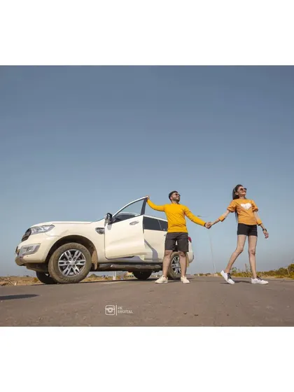 A wide shot capturing the feeling of a road trip and adventure. Using a car as a prop can help tell a story of your journey together.