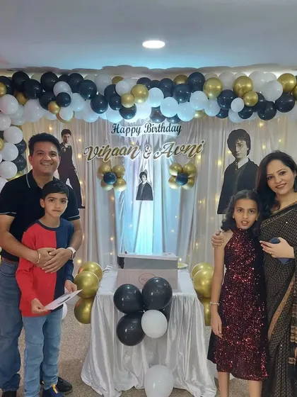 The birthday twins and their parents posing for a photo in front of the custom backdrop we created. We love capturing these happy family memories.