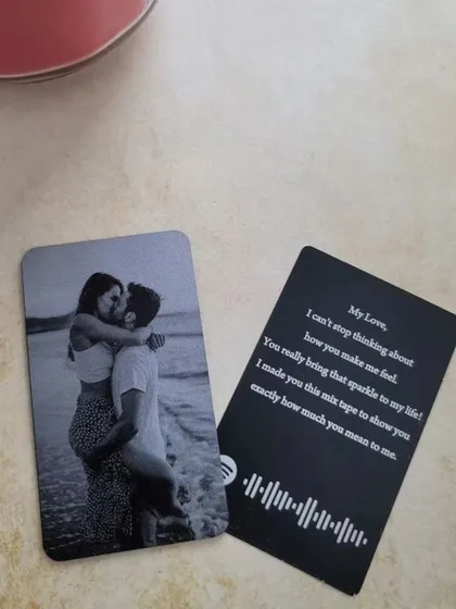 A romantic wallet card featuring a couple's photo on one side and a personal message with a scannable Spotify song code on the other.