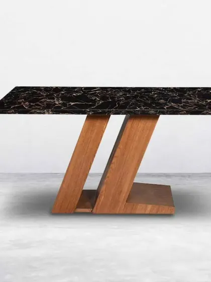 A unique dining table design combining a black marble top with a Z-shaped wooden base.