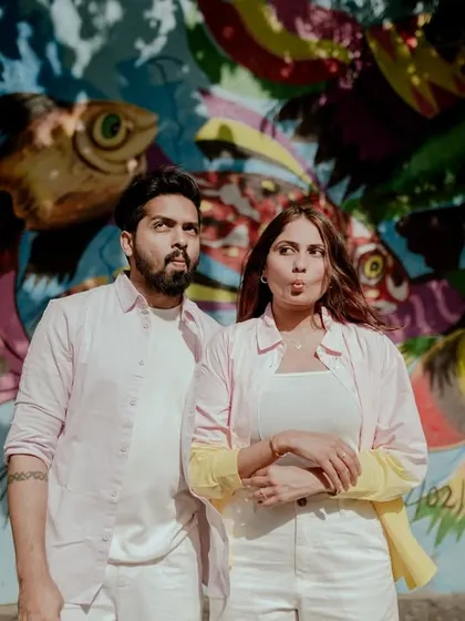 A playful moment captured, showing the couple's fun personality against a backdrop of fish murals.
