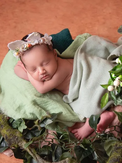 Our little princess in her garden of love. The mix of greenery and soft lighting creates a natural and serene environment for this beautiful shot.