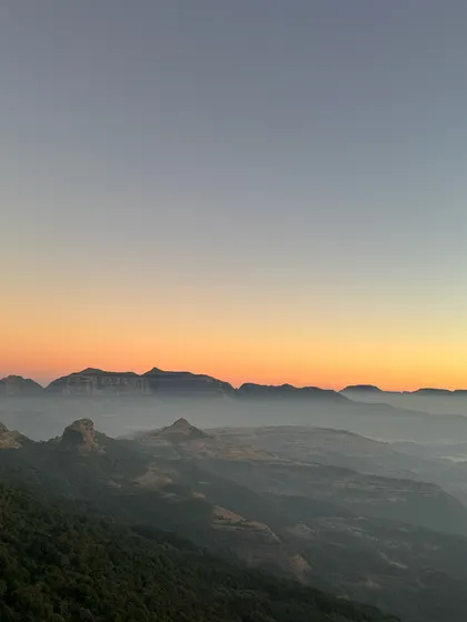 A beautiful sunrise over the Sahyadri mountains, as seen from Ratangad. The layers of hills fading into the distance create a stunning panorama.