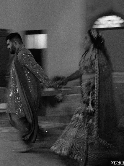 A creative motion-blur shot in black and white, capturing the energy and movement of a couple during their pre-wedding festivities at a palace.