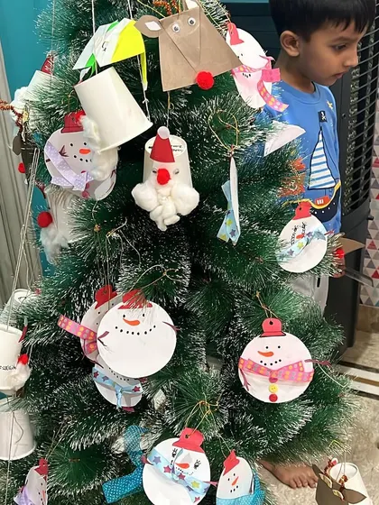 Decorating our Christmas tree with handmade ornaments. Each child contributes a craft, making our tree a beautiful collection of their creativity.