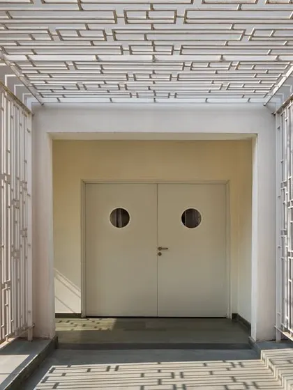 A new passageway with decorative screens was added to the auditorium to improve circulation and safety, complying with modern building codes for emergency egress.