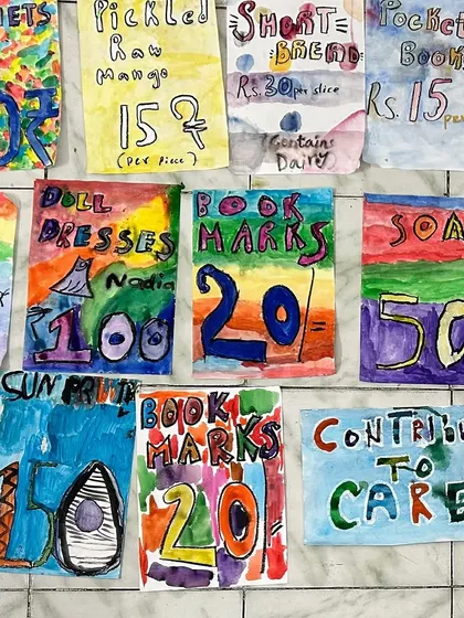 A colorful collection of posters made by the children for the flea market, advertising everything from bookmarks and soap to sun prints and resin pendants.