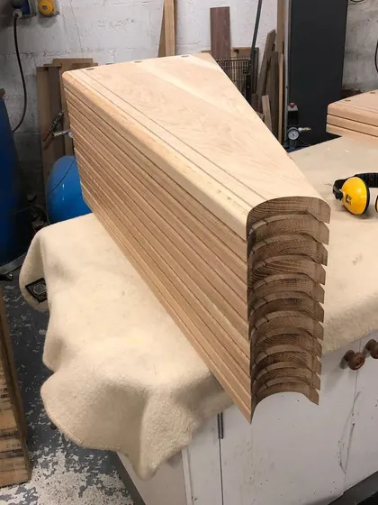 This shows the raw, unfinished oak treads after they have been cut to shape. You can see the detail of the walnut inlay before the final sanding and oiling.