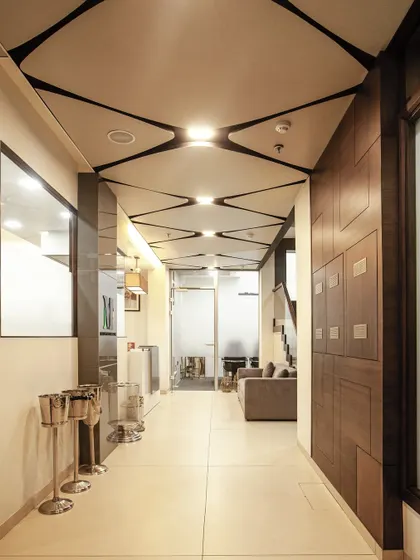 A seamless blend of contemporary design for a commercial office entrance. Clean lines, refined wooden wall panels, and a geometric ceiling pattern come together to create an entrance that reflects sophistication and intent.