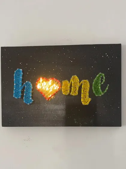 A closer look at my "Home" string art piece with the fairy lights turned on. The glowing heart creates such a warm and inviting ambiance.