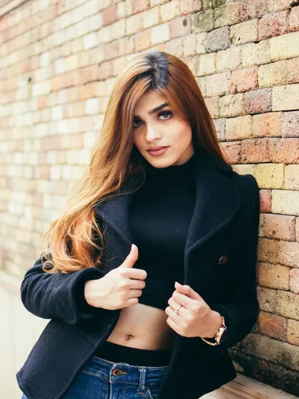 A classic street portrait against a brick wall, focusing on a clean composition and the subject's expression. This demonstrates a simple yet effective approach to urban lifestyle photography.