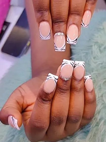 We teach various animal print techniques, including this stylish zebra pattern on a French tip base. This design adds a trendy edge to a classic look, complete with a touch of sparkle.