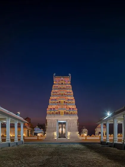 The main Gopuram illuminated at dusk. The lighting design was planned to enhance the architectural details and create a dramatic, spiritual presence at night.