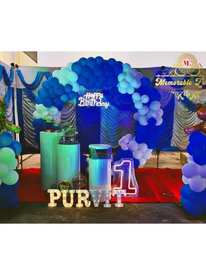 A blue-themed birthday setup with teddy bear props on top of balloon columns.