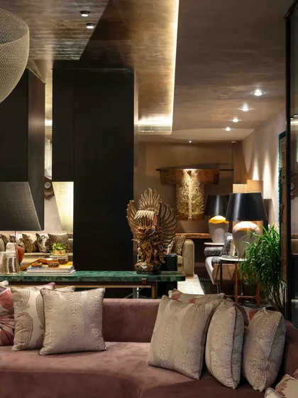 A glimpse of the living room's multiple seating areas, showing how we create different zones for conversation and relaxation within a single large space. A Balinese Garuda sculpture adds an international craft element.