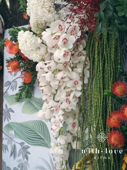 A close-up of the cascading white orchids against the botanical print backdrop of the 'Garden of Gaia' design.