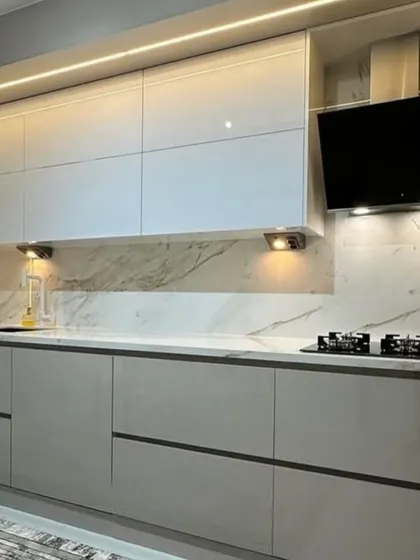 A modern entertainment solution integrated directly into the kitchen. This design features a wall-mounted television placed strategically above the counter, perfect for catching up on shows while cooking.