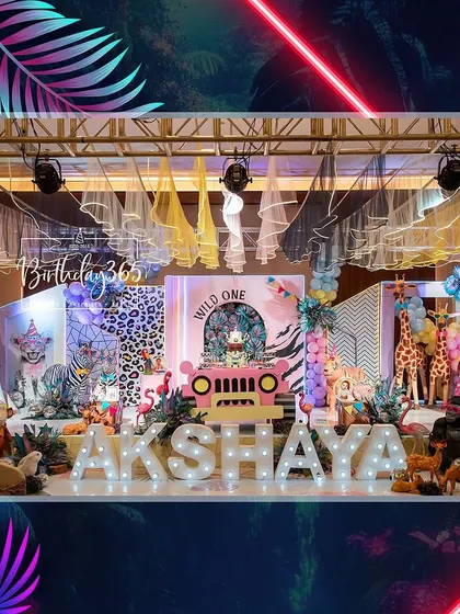 A vibrant neon jungle theme for Akshaya's "Wild One" party. The stage was filled with life-sized animal props, a pink jeep, and glowing neon lights for a unique and exciting atmosphere.