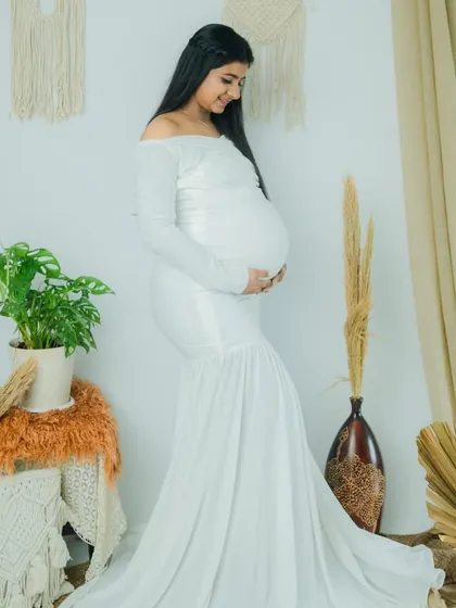 A side profile that beautifully captures the baby bump and her gentle smile. The makeup is soft, timeless, and perfect for creating lasting memories.