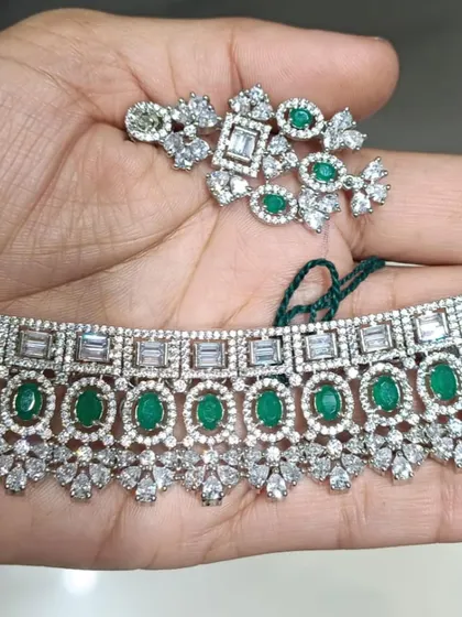 A stunning American Diamond choker with emerald green stones and baguette-cut diamonds. This is a very sophisticated design, perfect for formal events and cocktail parties.